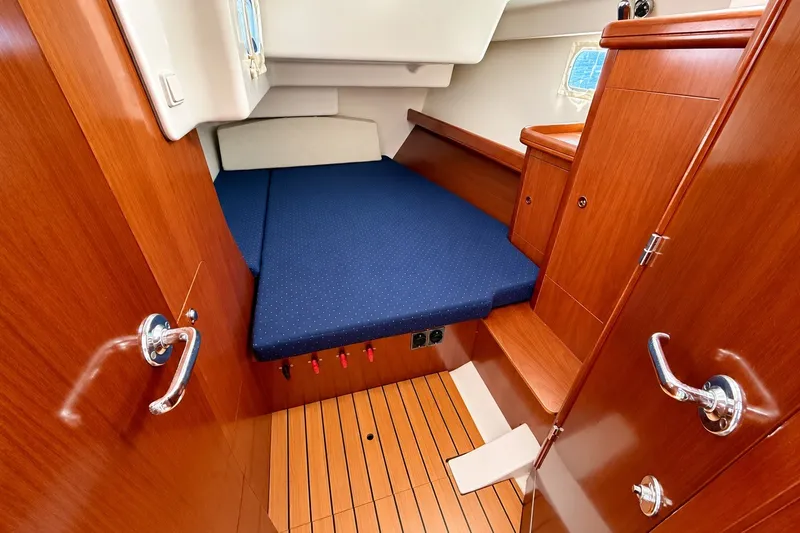 Slide: The Image of Interior cabin of 2005 Beneteau Oceanis 473 yacht with wooden finish and blue bedding. - 34