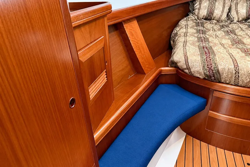 Slide: The Image of Interior of 2005 Beneteau Oceanis 473 yacht with wooden cabinetry and cozy bedding. - 28