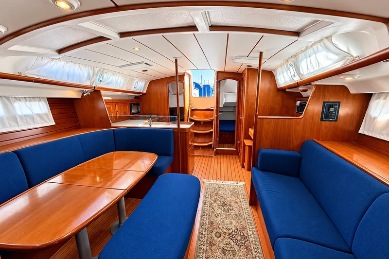 Slide: The Image of Interior of 2005 Beneteau Oceanis 473 yacht with blue seating and wooden finishes. - 13