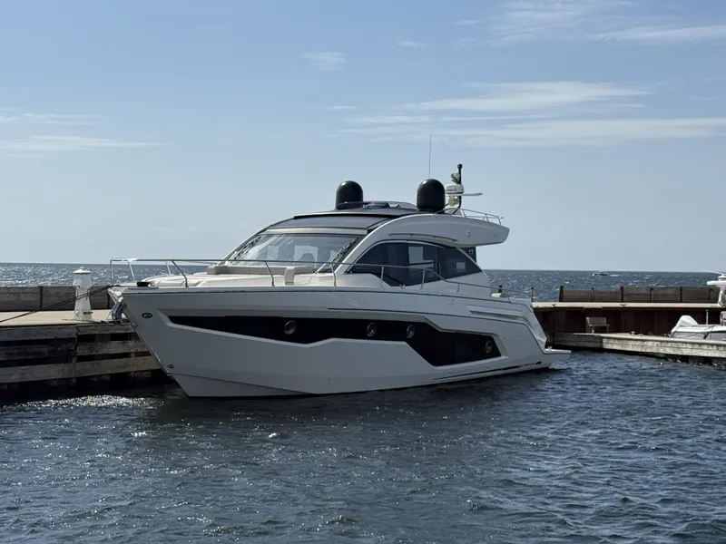 Slide: The Image of The 2019 Cranchi E 52S Evoluzione is docked, surrounded by calm waters. - 3