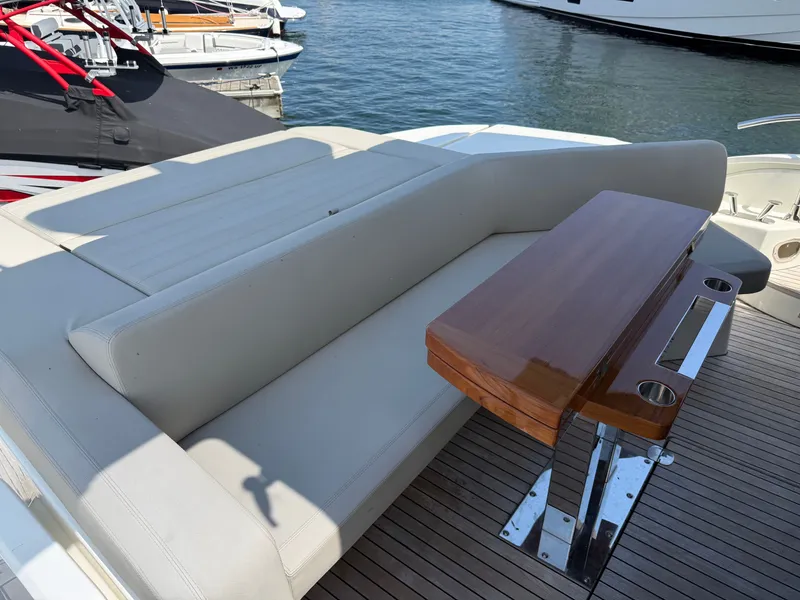 Slide: The Image of The image shows the deck of a 2019 Cranchi E 52S Evoluzione with an elegant bench and wooden table. - 8