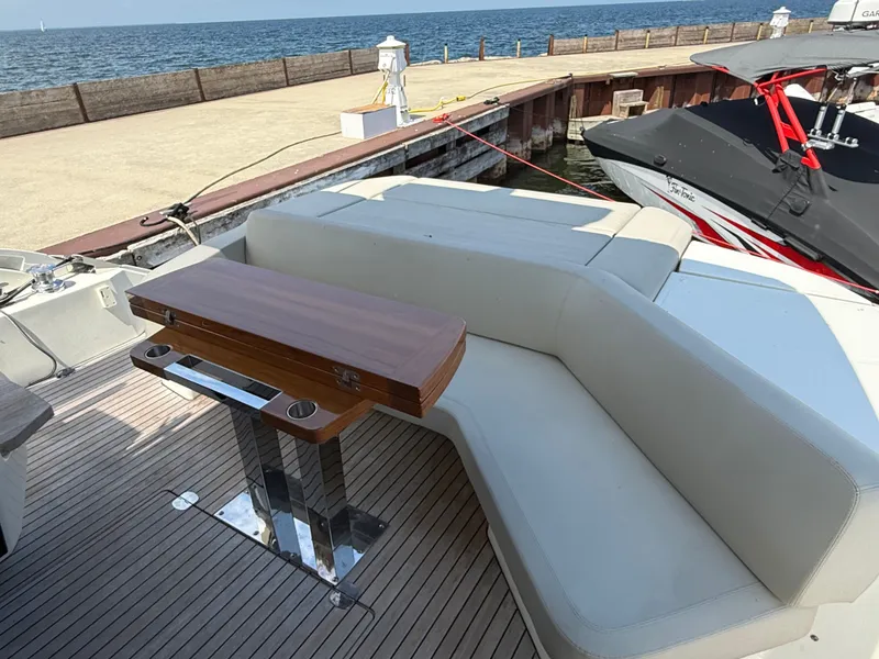 Slide: The Image of The image shows the stern of a 2019 Cranchi E 52S Evoluzione with an elegant seating area and wooden table. - 9
