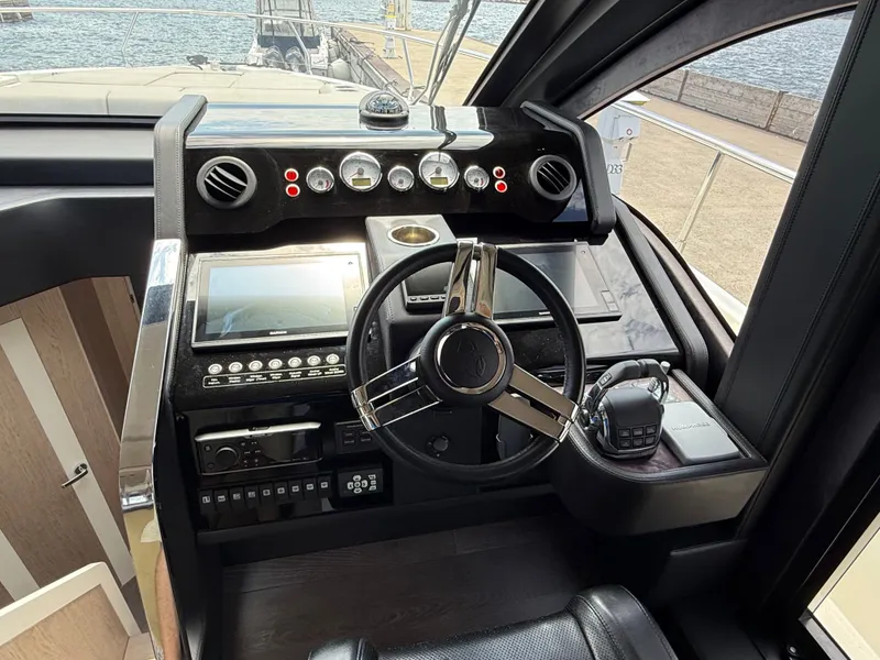 Slide: The Image of The cockpit of the 2019 Cranchi E 52S Evoluzione features a modern steering wheel with instruments and screens. - 35