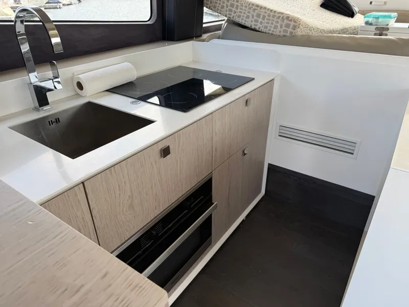 Slide: The Image of The 2019 Cranchi E 52S Evoluzione kitchen features a modern design with a cooktop and sink. - 32