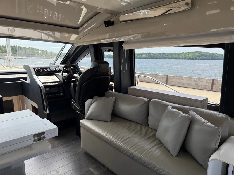 Slide: The Image of Interior of a 2019 Cranchi E 52S Evoluzione with sofa and helm, overlooking the water. - 26