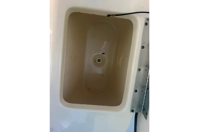Slide: The Image of Livewell compartment in a 2023 Key West 239 FS boat, featuring a drain plug. - 18