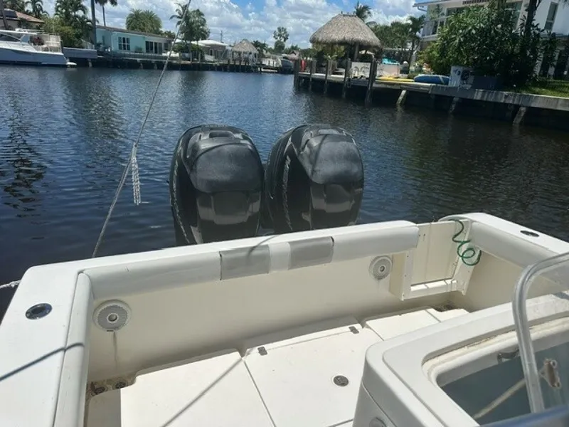 Slide: The Image of A 2018 Mako 284 boat with twin outboard engines, docked in a calm canal. - 12