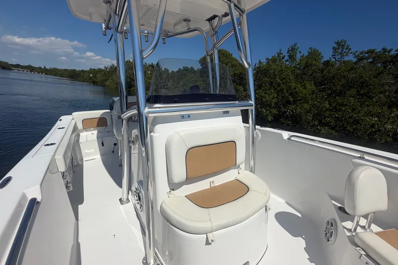 Slide: The Image of 2013 Sportsman Heritage 229 Center Console boat on calm water, featuring sleek seating and console design. - 16