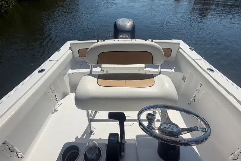 Slide: The Image of 2013 Sportsman Heritage 229 Center Console boat interior with steering wheel and seating. - 18