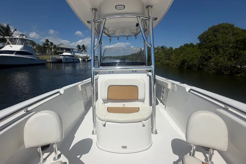 Slide: The Image of 2013 Sportsman Heritage 229 Center Console boat on a sunny waterway with lush greenery. - 15