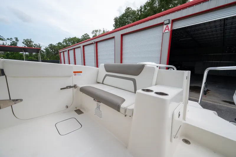 Slide: The Image of 2020 World Cat 320 DC boat interior with seating and cup holders near storage facility. - 12