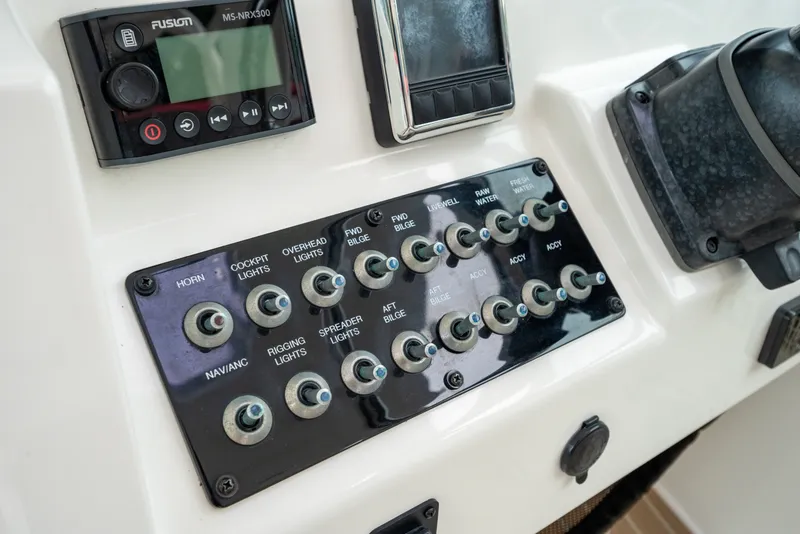 Slide: The Image of Control panel of a 2020 World Cat 320 DC boat with labeled switches and a Fusion MS-NRX300. - 18