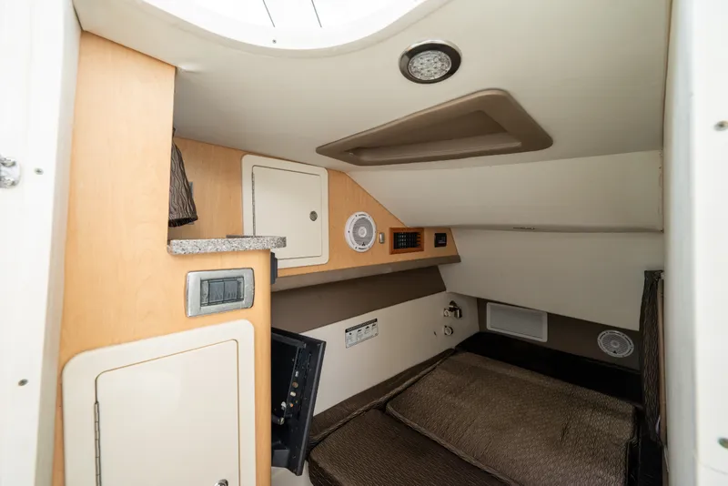Slide: The Image of Interior cabin of 2020 World Cat 320 DC boat, featuring cozy sleeping area and storage. - 13