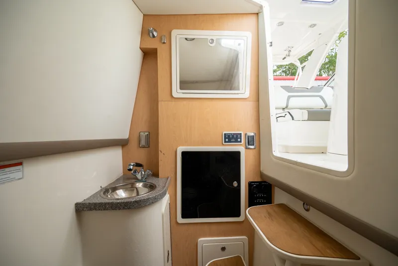 Slide: The Image of Interior of 2020 World Cat 320 DC boat featuring sink, mirror, and seating area. - 19