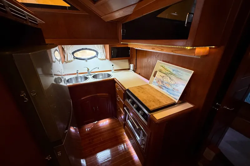 Slide: The Image of 1988 Californian 45 Motor Yacht kitchen with wood cabinetry, dual sinks, and modern appliances. - 19