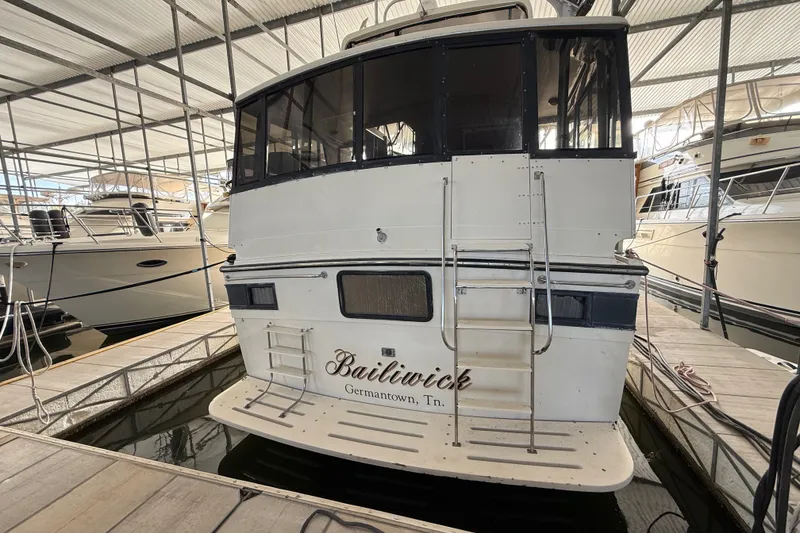 Slide: The Image of 1988 Californian 45 Motor Yacht docked in marina, rear view with ladder and nameplate. - 12