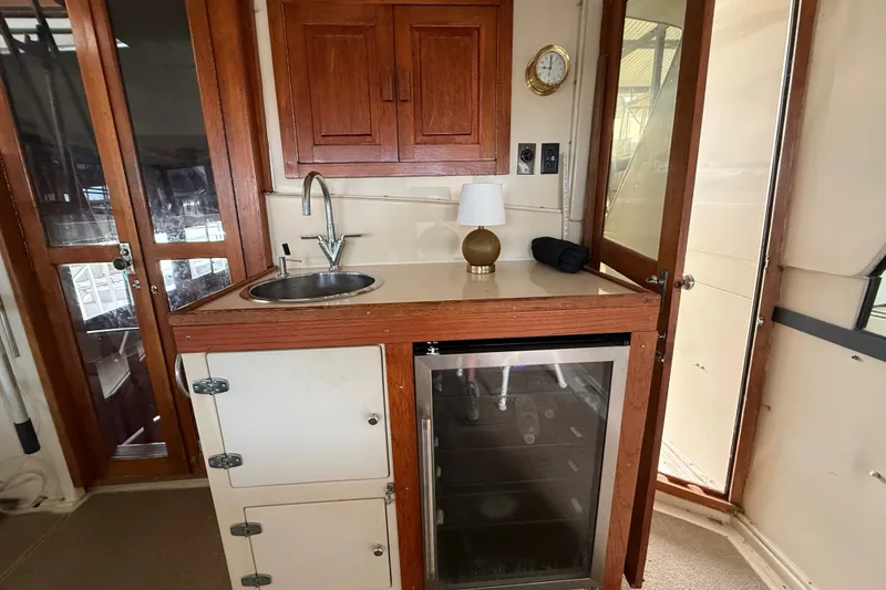 Slide: The Image of 1988 Californian 45 Motor Yacht interior with sink, mini fridge, and wooden cabinetry. - 6