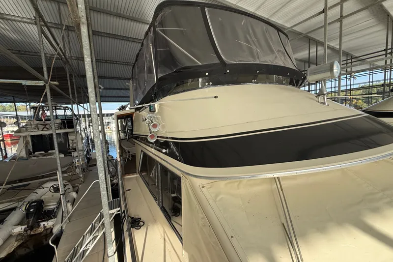 Slide: The Image of 1988 Californian 45 Motor Yacht docked in a covered marina, showcasing its classic design. - 8