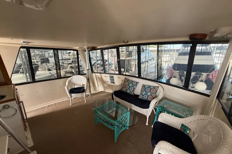 Slide: The Image of 1988 Californian 45 Motor Yacht interior with wicker seating and marina view. - 5