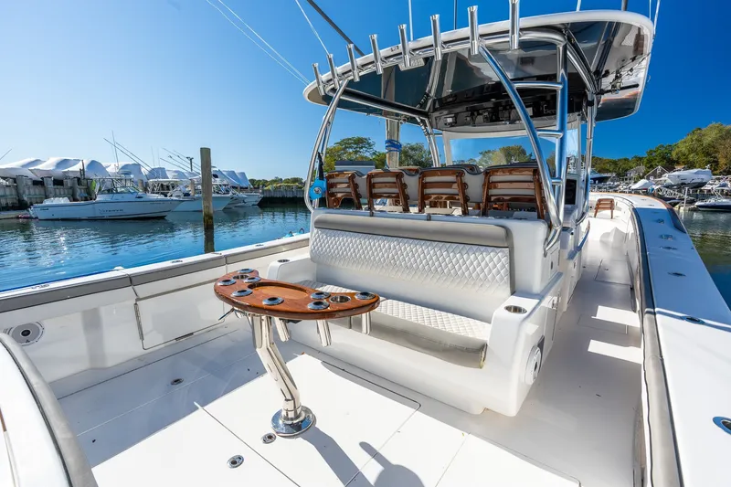 Slide: The Image of 2022 Valhalla V-46 boat interior with seating and rod holders, docked at a marina. - 18