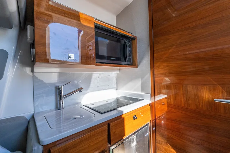 Slide: The Image of Luxurious 2022 Valhalla V-46 yacht kitchen with sleek wood cabinetry and modern appliances. - 37