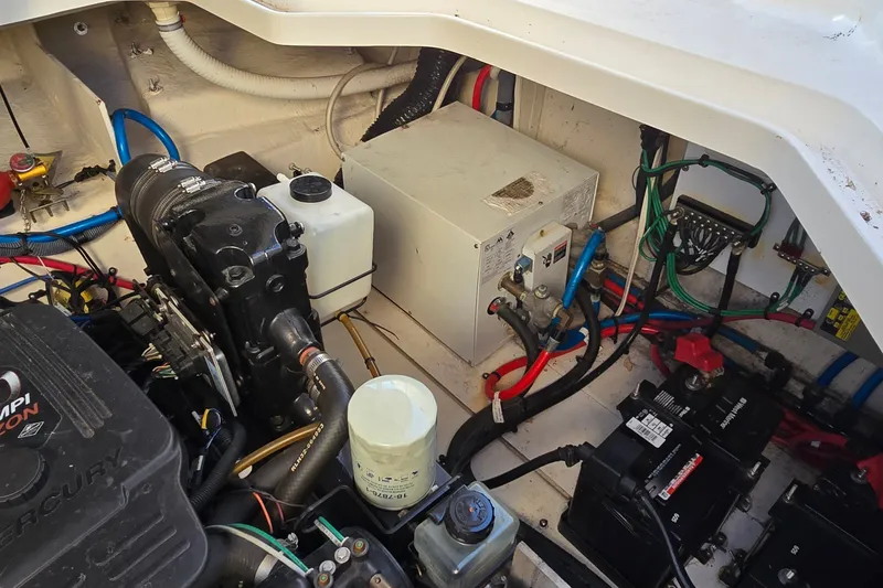 Slide: The Image of Engine compartment of a 2005 Sea Ray Sundancer 260, showcasing mechanical components and wiring. - 24