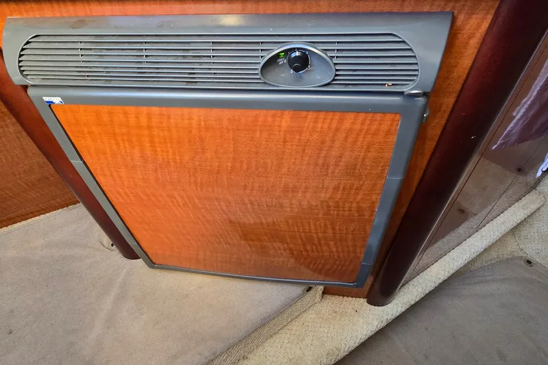 Slide: The Image of 2005 Sea Ray Sundancer 260 cabin interior with wooden panel and vent. - 19