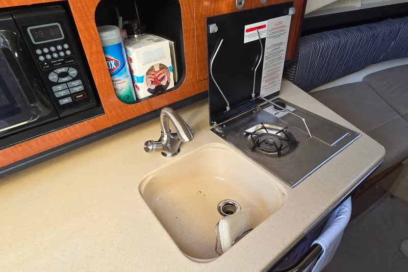Slide: The Image of Compact kitchen area in a 2005 Sea Ray Sundancer 260 boat with sink and stove. - 18