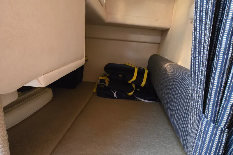 Slide: The Image of Interior cabin of 2005 Sea Ray Sundancer 260 with striped cushions and storage bags. - 15