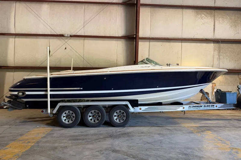 Slide: The Image of 2003 Chris-Craft Launch 28 boat on trailer in warehouse setting. - 1