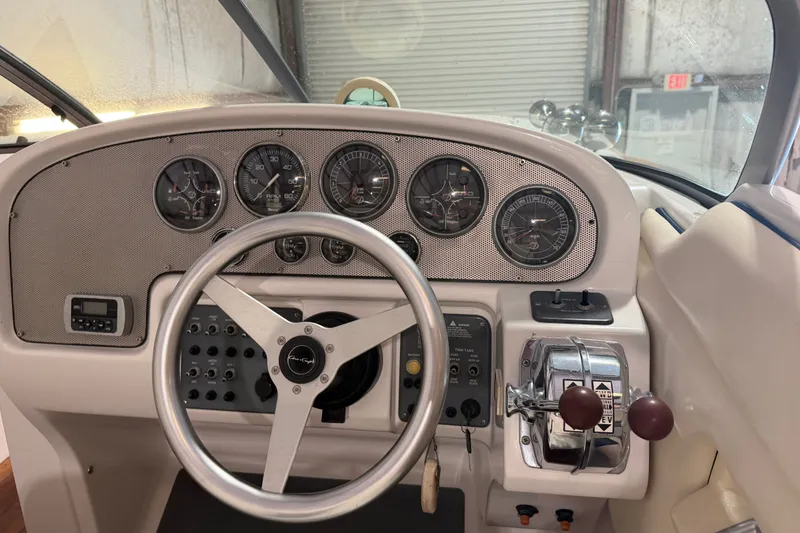 Slide: The Image of 2003 Chris-Craft Launch 28 dashboard with steering wheel and control panel in a boat interior. - 6