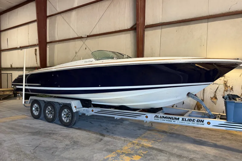 The Image of 2003 Chris-Craft Launch 28 boat on trailer in indoor storage facility. - 0