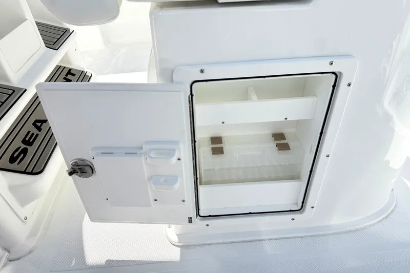 Slide: The Image of Open storage compartment on 2027 Sea Hunt BX28 boat, showcasing interior shelving. - 18