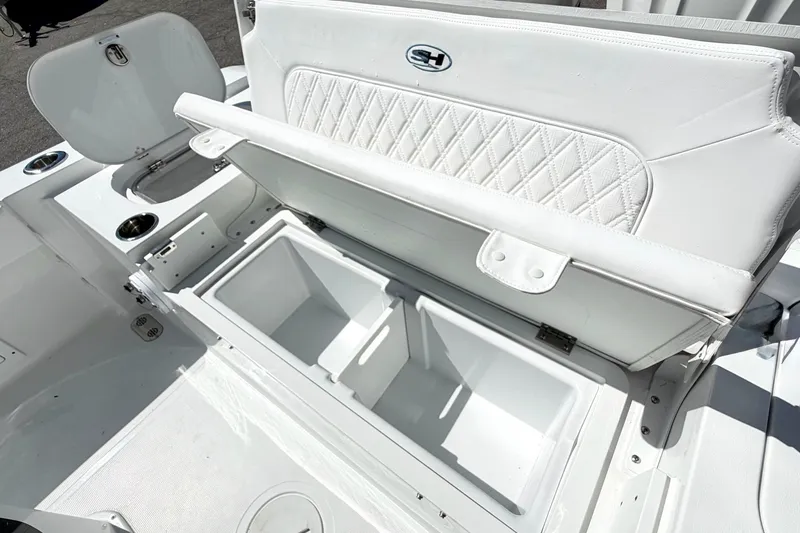 Slide: The Image of 2027 Sea Hunt BX28 boat interior with open storage compartments and cushioned seating. - 12