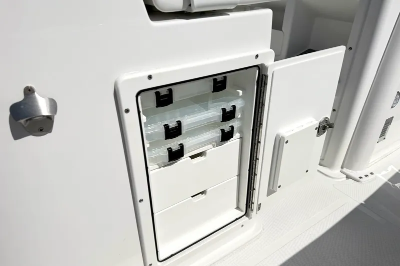 Slide: The Image of Storage compartment on a 2027 Sea Hunt BX28 boat, featuring organized tackle boxes. - 20
