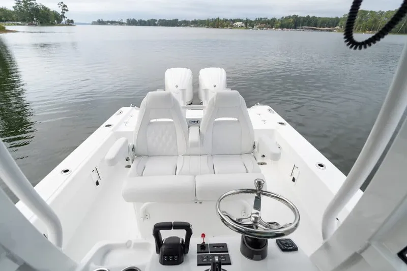 Slide: The Image of Manufacturer Provided Image: 2027 Sea Hunt BX28 boat interior with dual seats and steering wheel on calm water. - 37