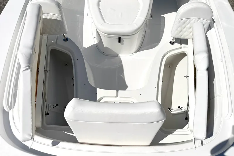 Slide: The Image of 2027 Sea Hunt BX28 boat interior with white cushioned seating and storage compartments. - 27
