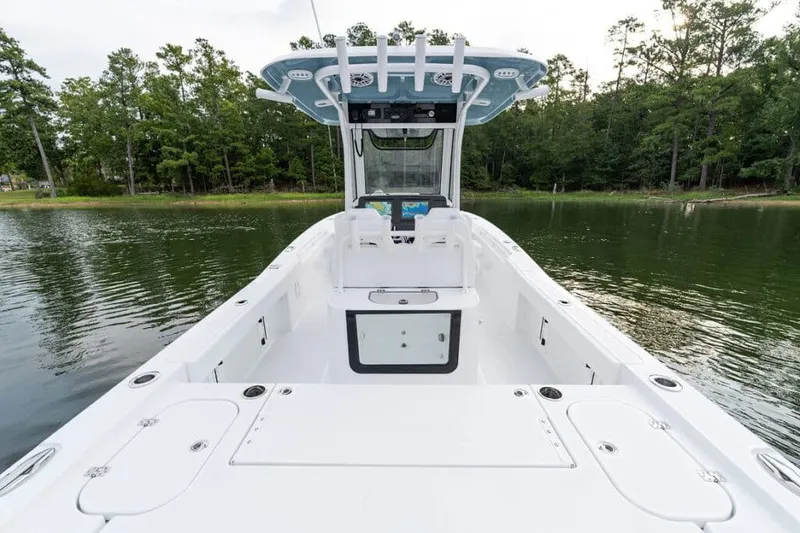 Slide: The Image of Manufacturer Provided Image: 2027 Sea Hunt BX28 boat on calm water, surrounded by lush greenery. - 40