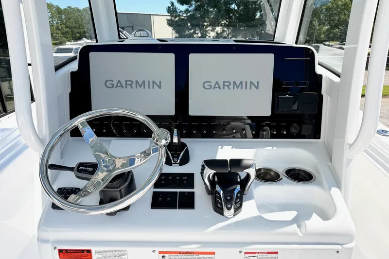 Slide: The Image of 2027 Sea Hunt BX28 boat dashboard with dual Garmin displays and steering wheel. - 9