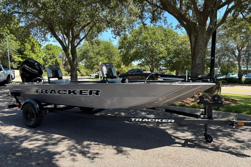 The Image of 2027 Tracker Panfish 17 boat on trailer, parked under trees in a sunny setting. - 0