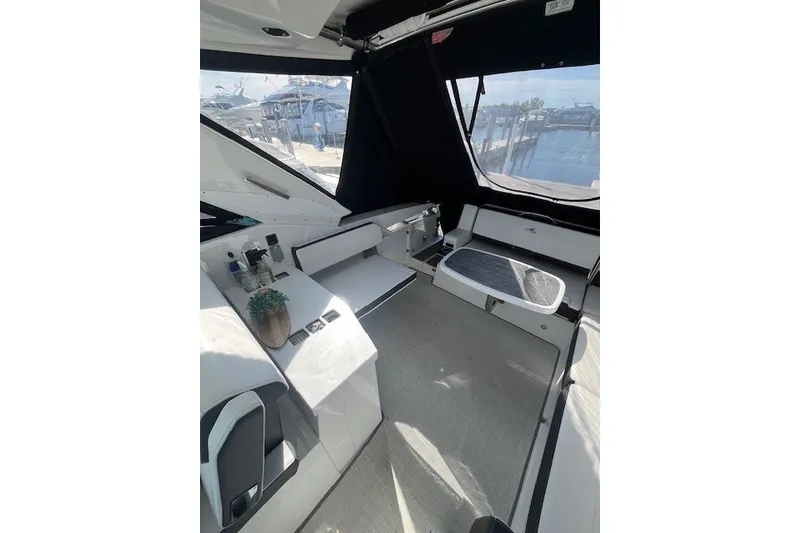 Slide: The Image of 2024 Monterey 378SS Super Sport boat interior with seating and table, dockside view. - 7