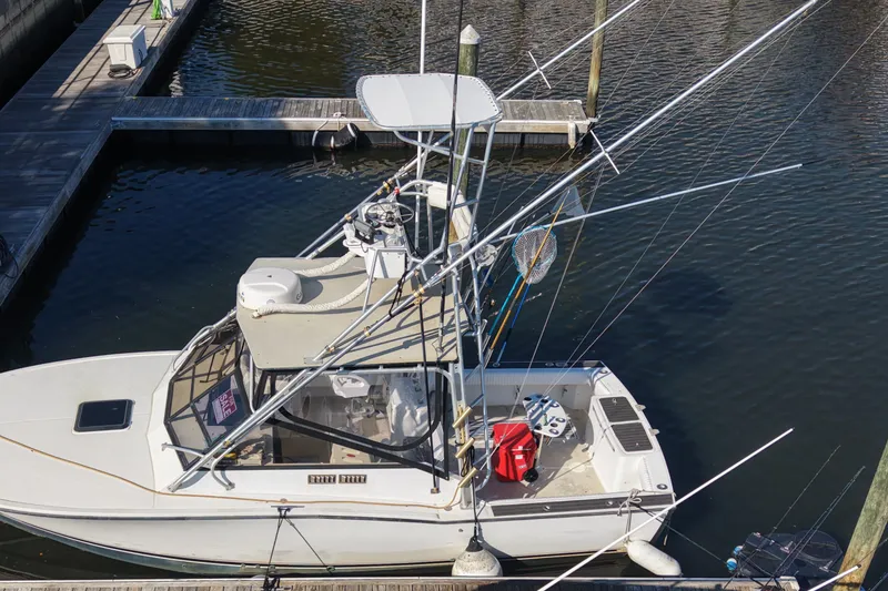 Slide: The Image of 1995 Carolina Classic 28 boat docked, equipped with fishing gear and a "For Sale" sign. - 6
