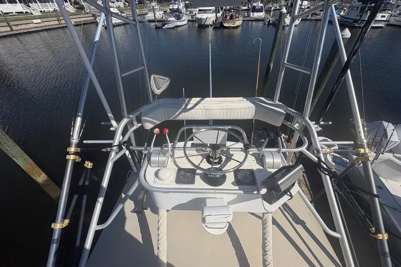 Slide: The Image of 1995 Carolina Classic 28 boat helm with steering wheel and controls, docked at marina. - 4