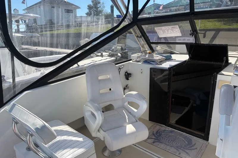 Slide: The Image of Interior of a 1995 Carolina Classic 28 boat with white seating and helm. - 22