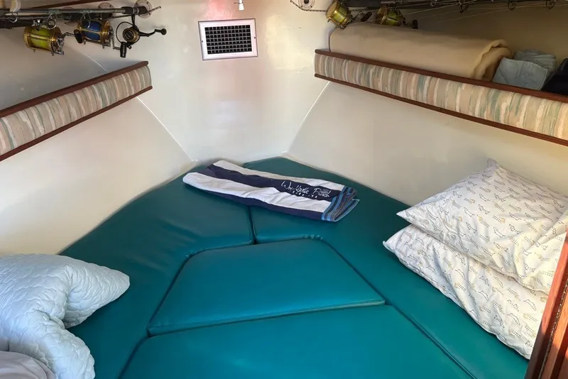 Slide: The Image of Cozy cabin interior of a 1995 Carolina Classic 28 boat with teal cushions and fishing rods. - 35