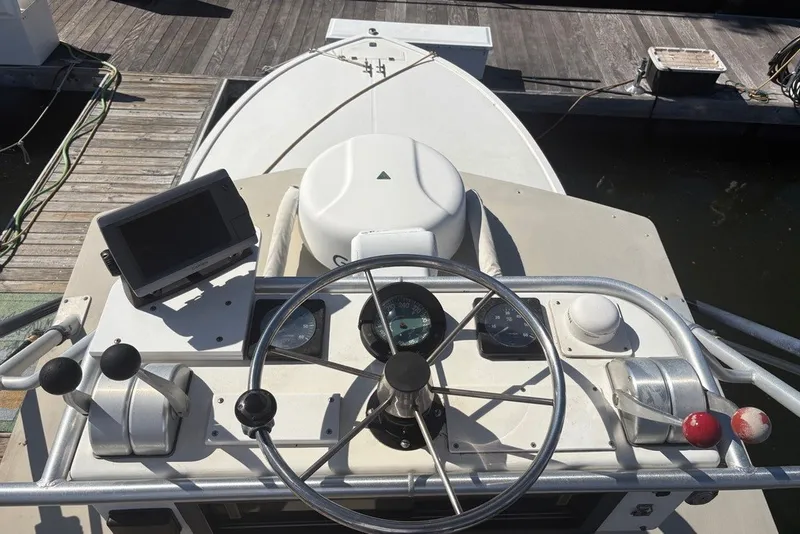 Slide: The Image of Helm of a 1995 Carolina Classic 28 boat with steering wheel and controls. - 13