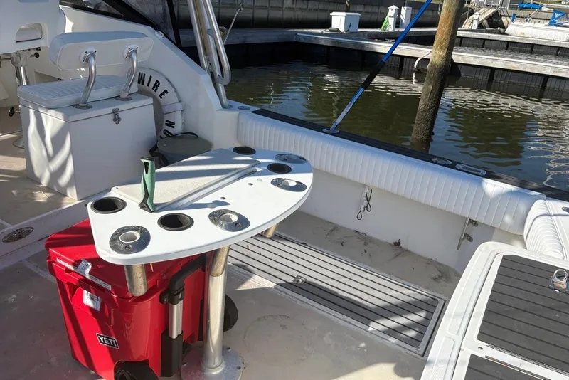 Slide: The Image of 1995 Carolina Classic 28 boat interior with fishing rod holders and a red Yeti cooler. - 3