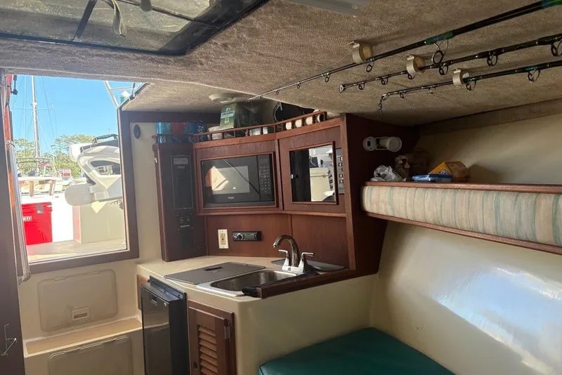 Slide: The Image of Interior of a 1995 Carolina Classic 28 boat with kitchenette and fishing rods. - 43