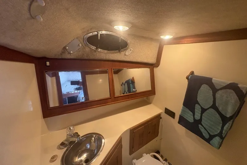 Slide: The Image of Interior of a 1995 Carolina Classic 28 boat bathroom with sink, mirror, and towel. - 45