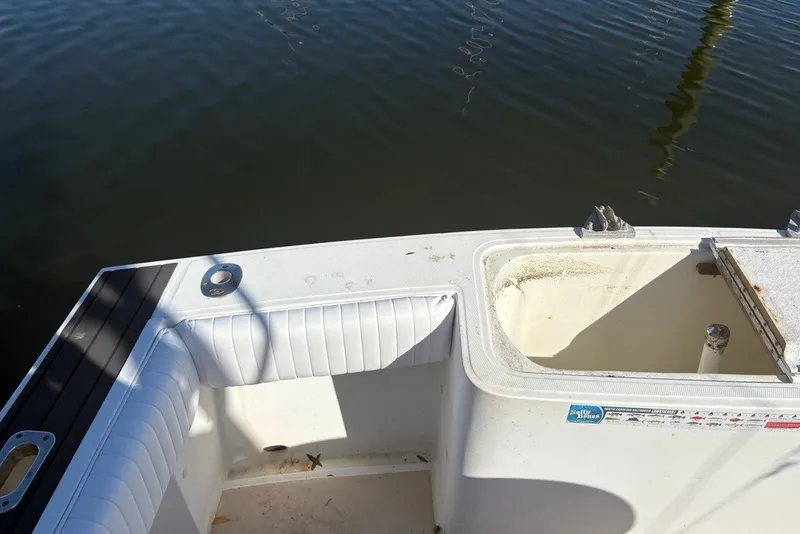Slide: The Image of 1995 Carolina Classic 28 boat deck with seating and storage, near calm water. - 32